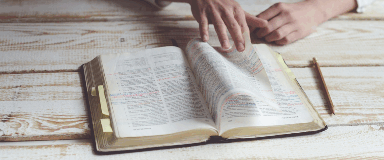 Person flipping through pages of the Bible