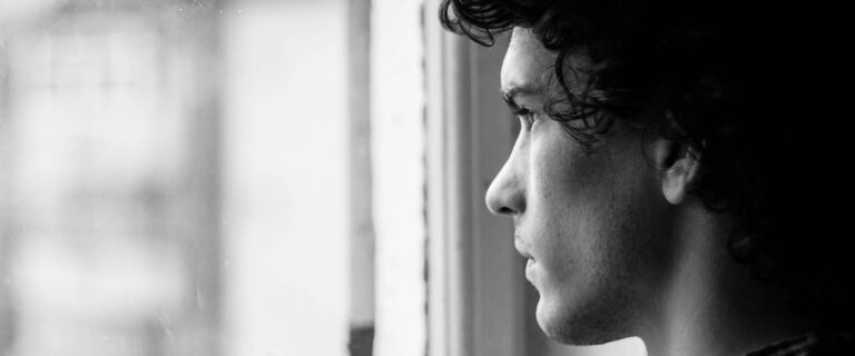 A young man looks out a window