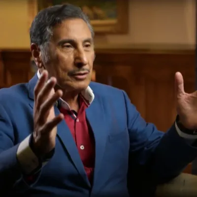 Dr. Youssef sits in a chair, gesturing with both hands
