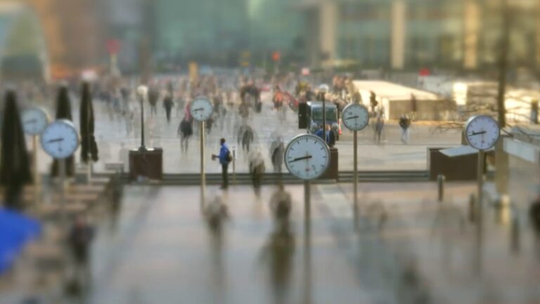 A blurry, stylized image of people and clocks