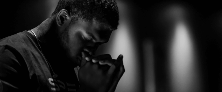 Man with head down praying